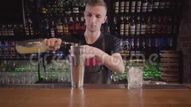 酒保混合学家使用摇床和制作酒精鸡尾酒与不同的饮料在美丽的现代<strong>酒吧</strong>。 关门